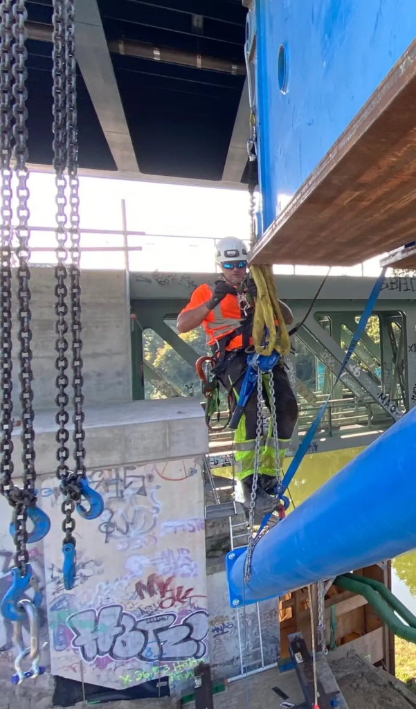 Technician Working with Chain Hoists Beneath a Structur