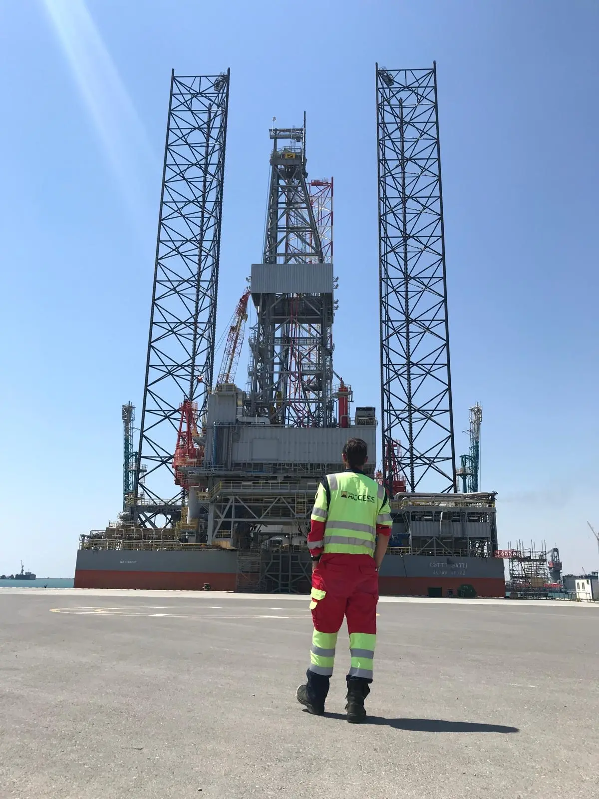 Technicien RAO devant une plateforme auto-élévatrice au port