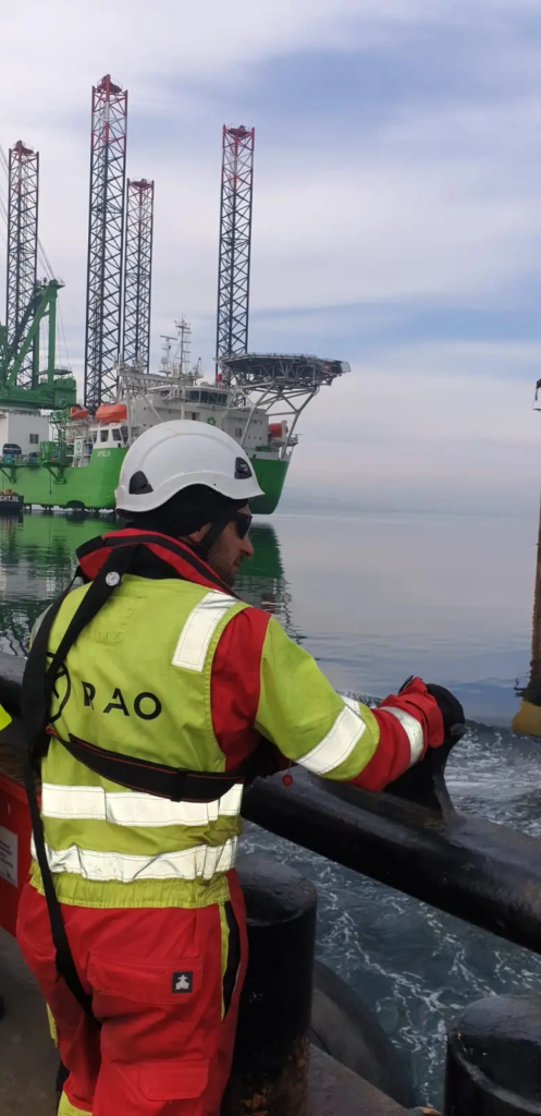 Technicien RAO sur le pont d’une unité offshore à proximité de plateformes