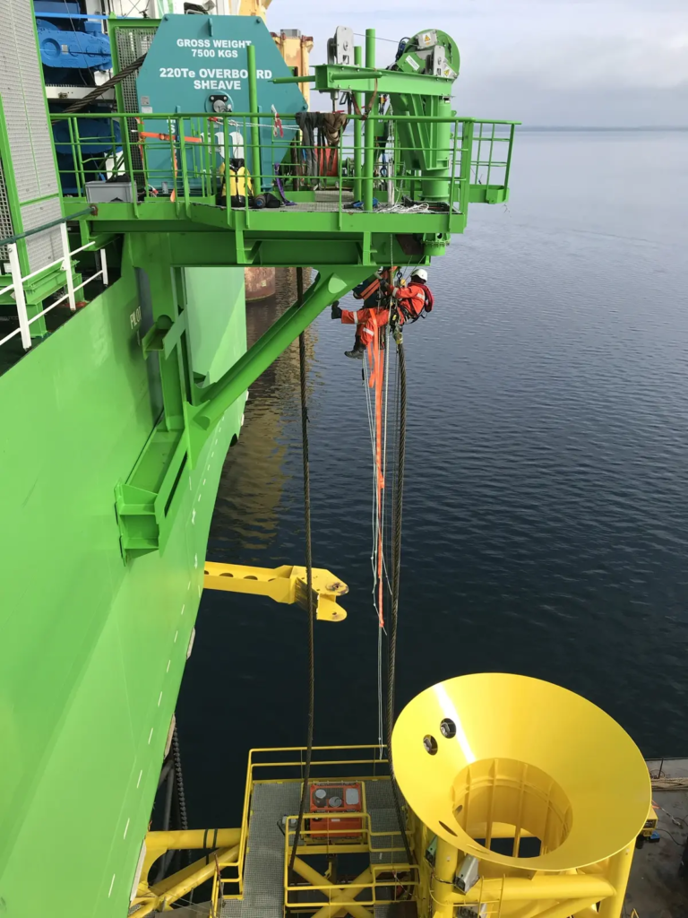 Technicien cordiste sur le flanc d’une unité d’installation offshore