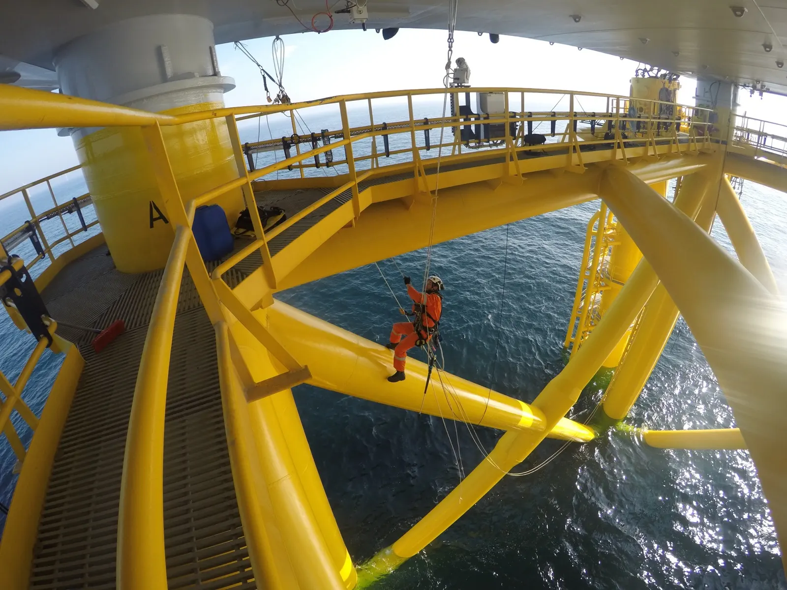 Technik dostępu linowego na żółtej konstrukcji fundamentu offshore nad wodą