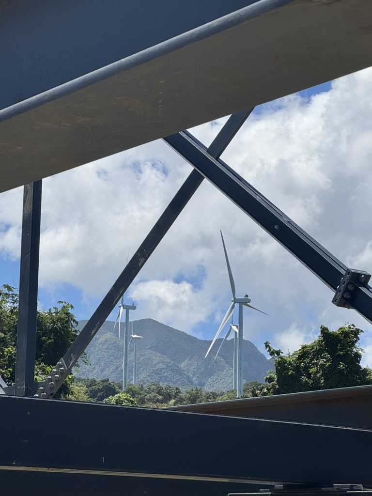 View through a steel structure of wind turbines and mountains in the background