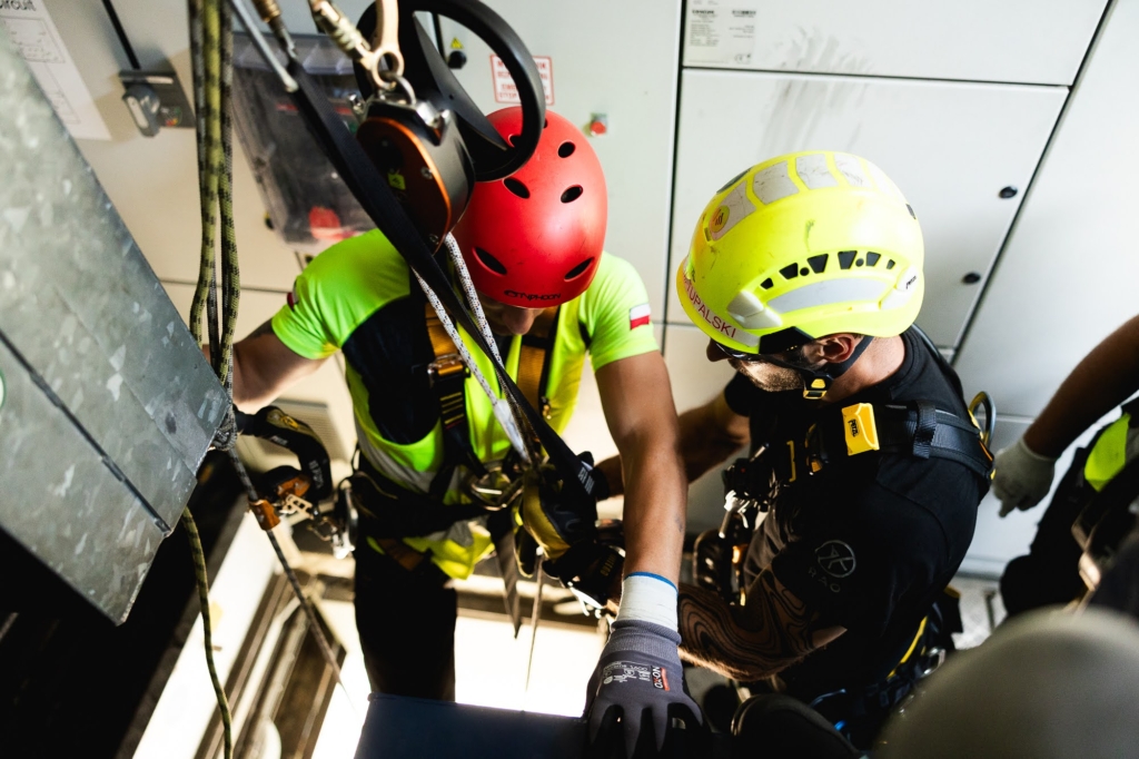 Deux techniciens dans la nacelle d'une éolienne pendant un exercice d'évacuation, l'un portant un casque rouge